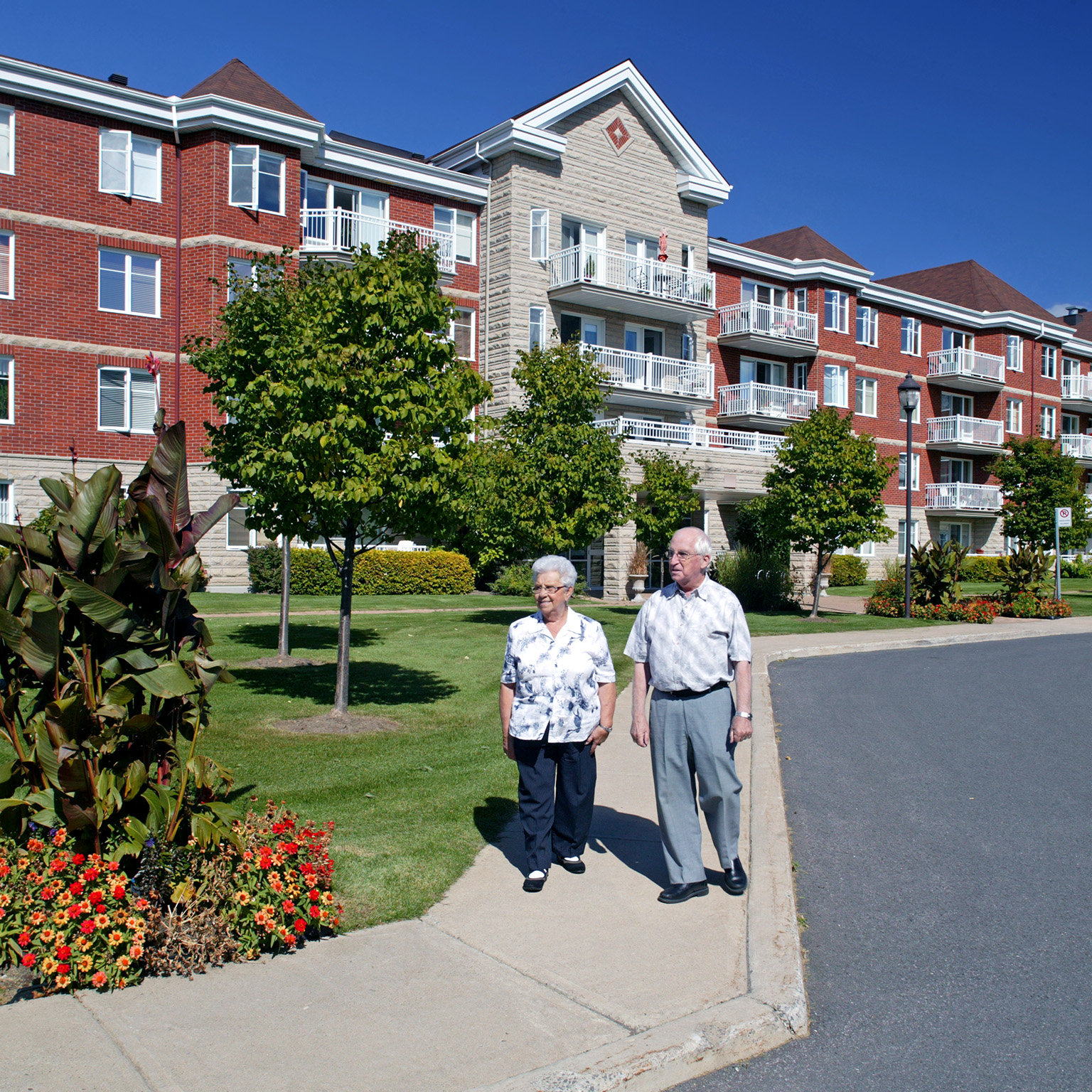 A senior couple walking outdoors in a senior living community.