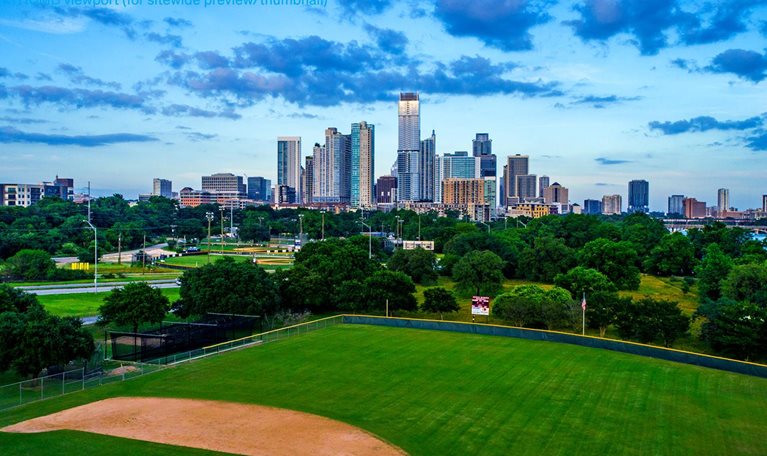 Wide angle view of the skyline with tall towers and green grass and a walkway