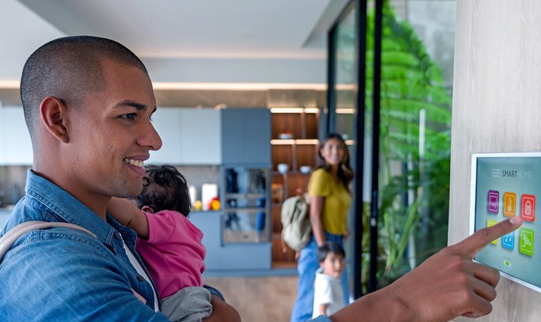 Happy Latin American family leaving a luxury apartment locking the door using a home automation system