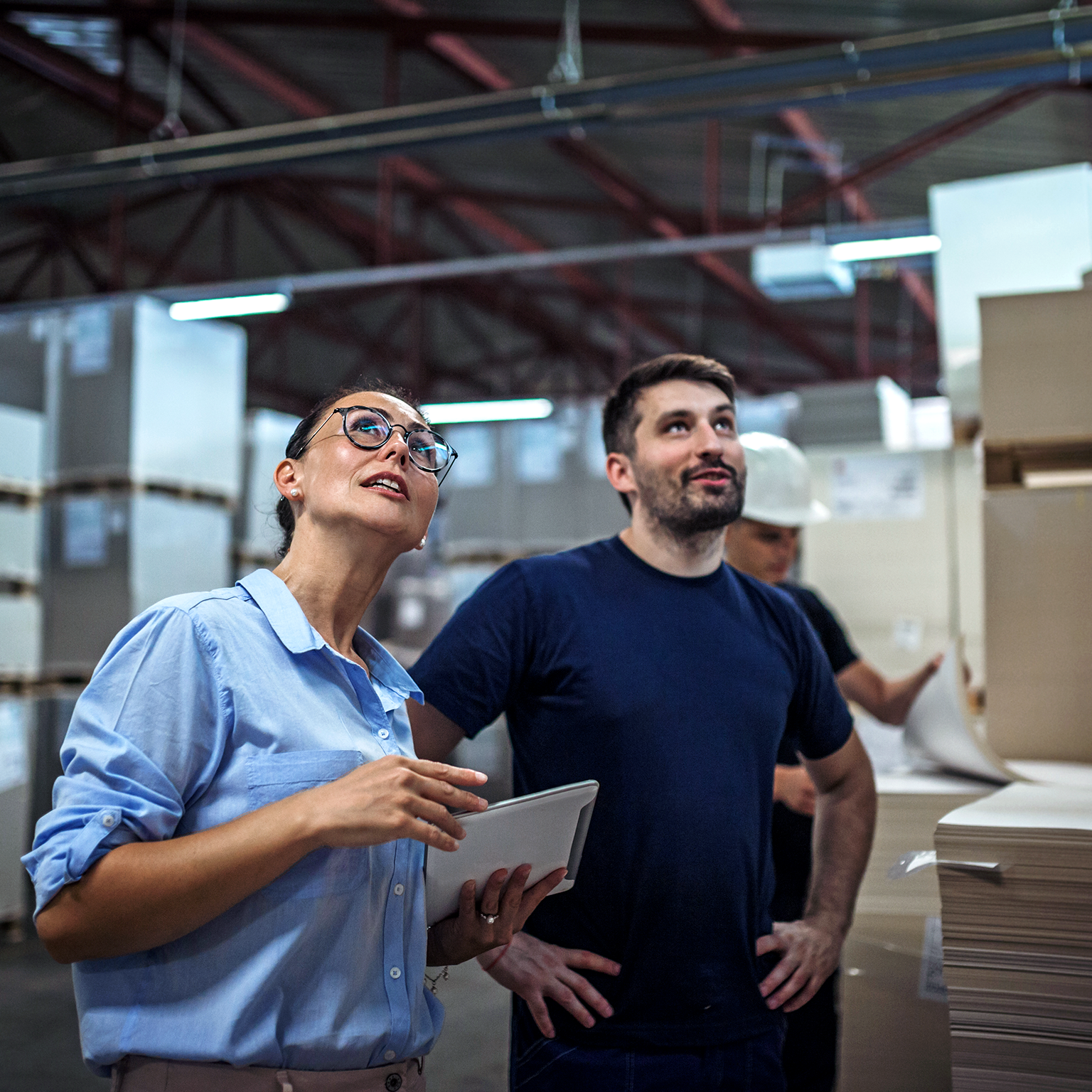 Image of a warehouse supervisor walking and talking with a senior manager while inspecting a warehouse.