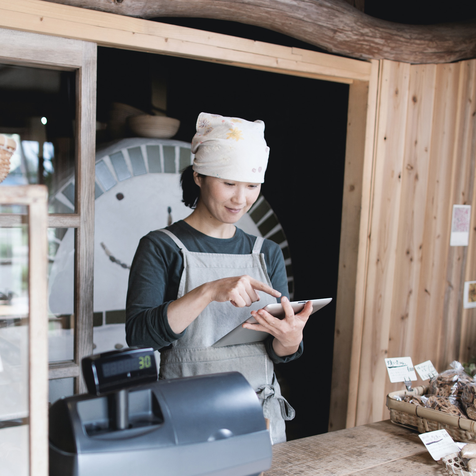 Woman using tablet computer in a small bakery