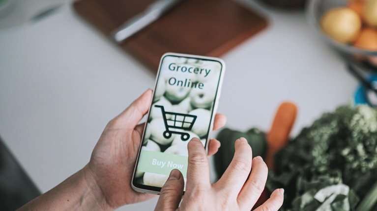 Person doing online shopping at kitchen counter