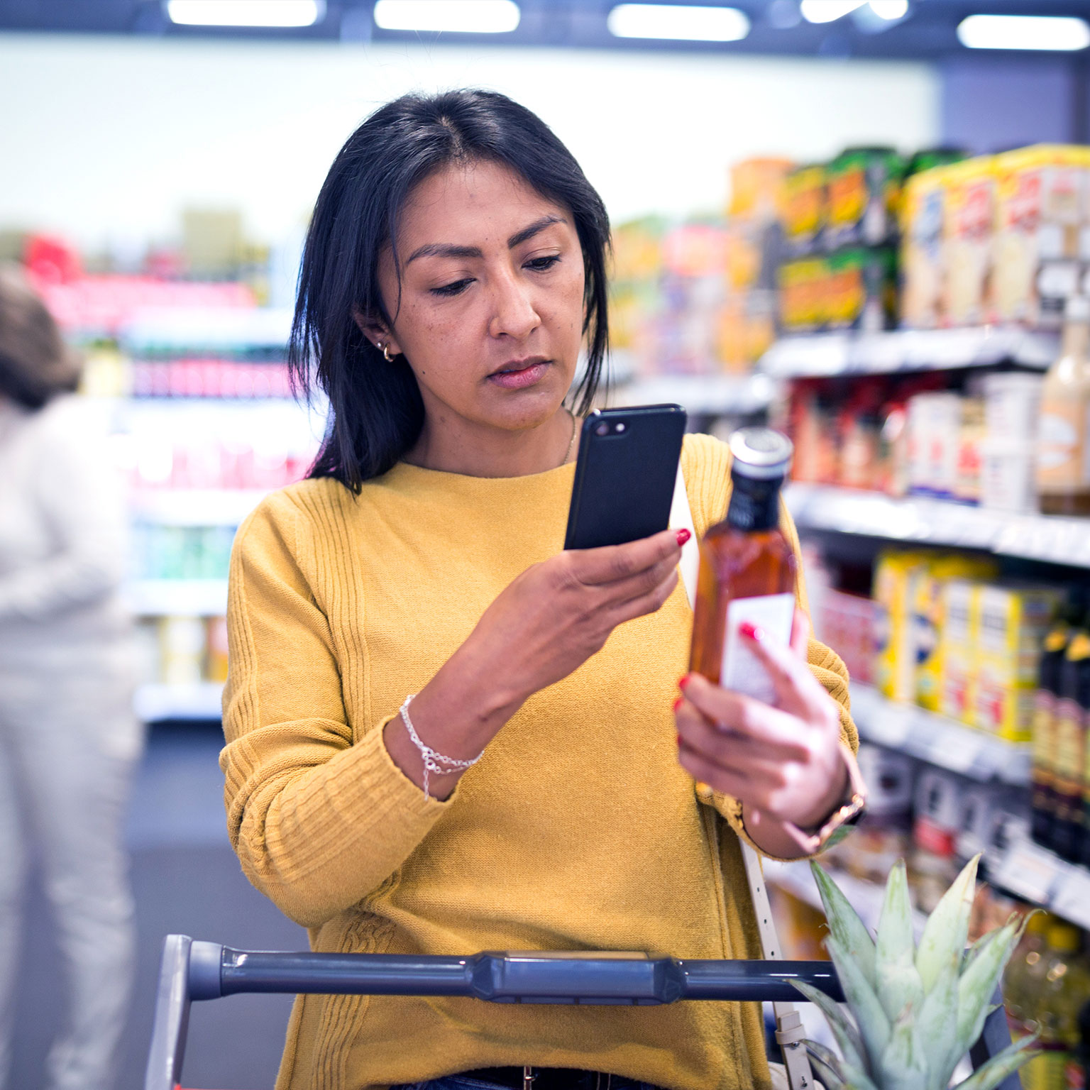 Woman holding phone in a grocery store