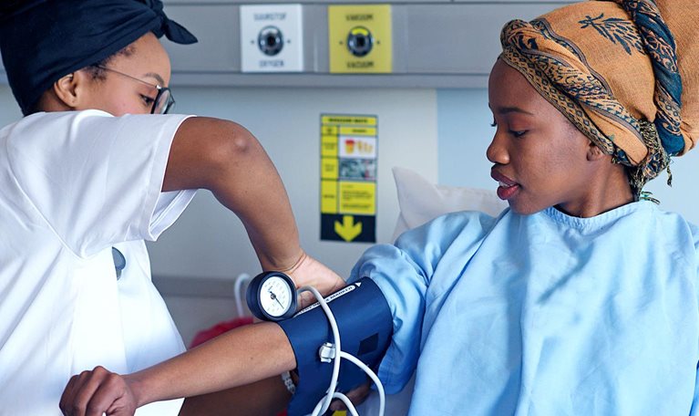 An African doctor taking a patient's blood pressure