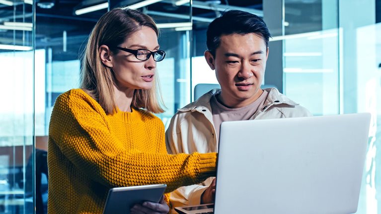 Business meeting of two employees discussing a project in a modern office