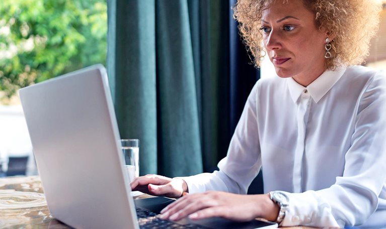 Freelancer working on her laptop at the restaurant - stock photo