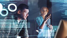 Shot of two programmers working together on a computer code at night - stock photo
