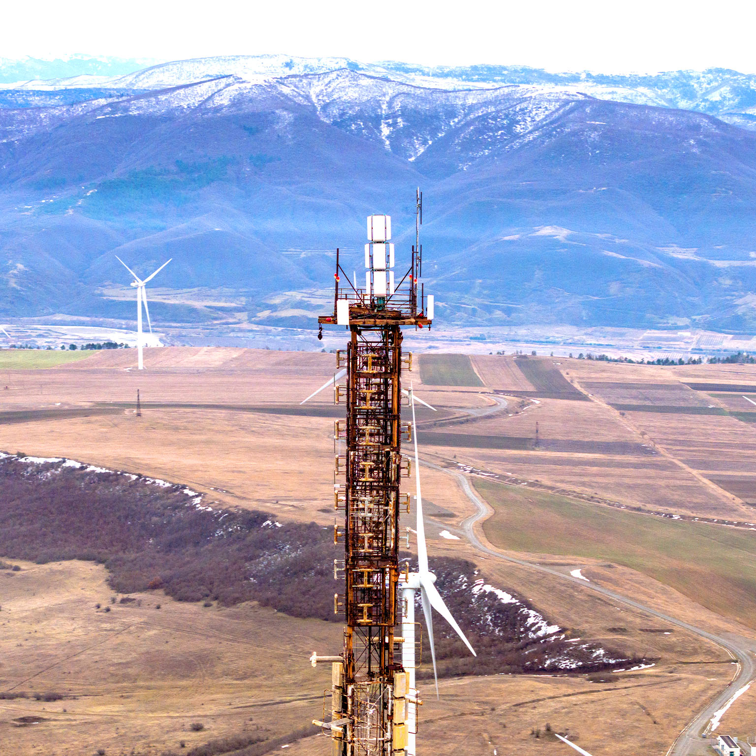 Communication tower and wind turbines on land in Georgia. Taken via drone. - stock photo