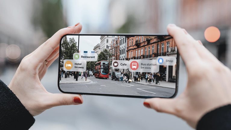 Young woman locating direction with augmented reality technology on smartphone on street.
