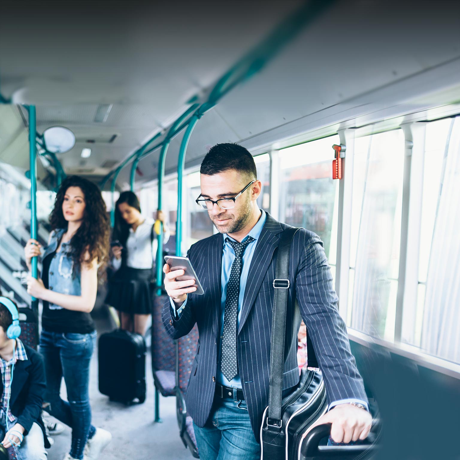 Front view of a businessman looking at his 5G phone while riding on public transportation. 