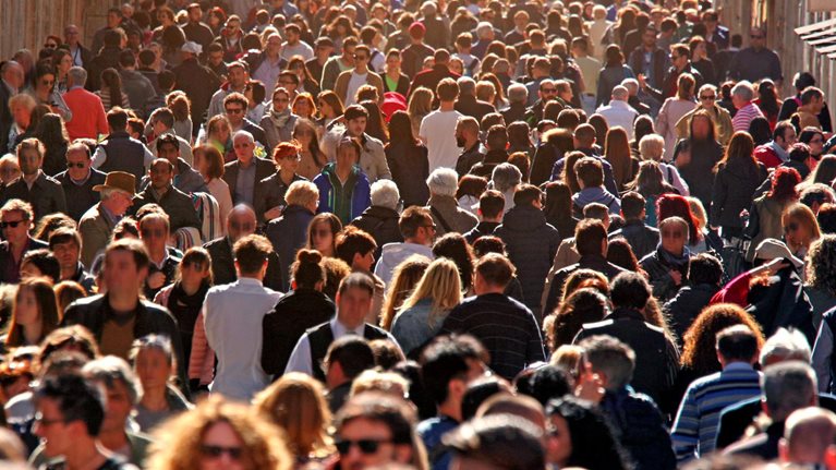 Image of large group of people crowding Rome's downtown streets in a sunny day.