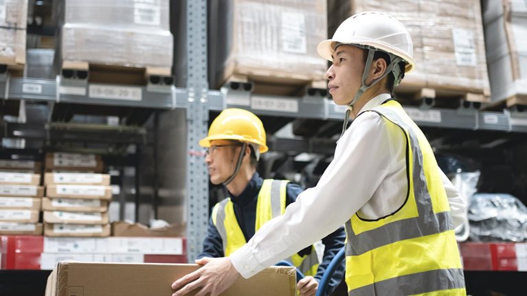 Two workers moving goods in a warehouse