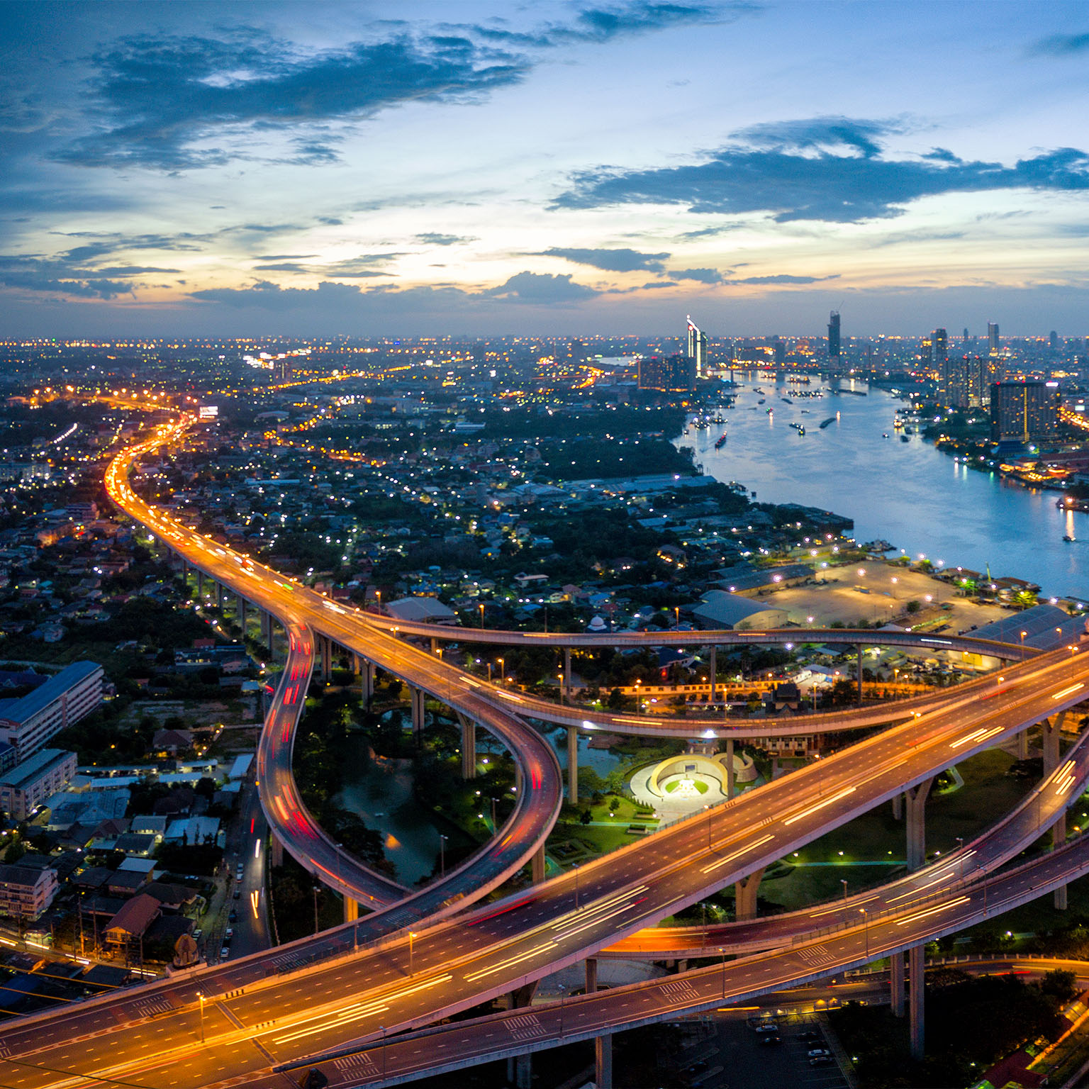 Aerial view of Bhumibol suspension bridge cross over Chao Phraya River in Bangkok city with car on the bridge at sunset sky and clouds in Bangkok Thailand. - stock photo