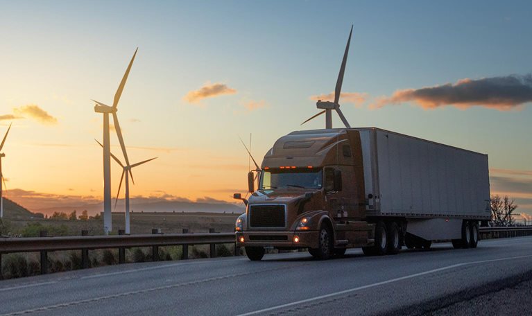 Semi truck speeding in front of Wind turbines in Utah, USA - stock photo