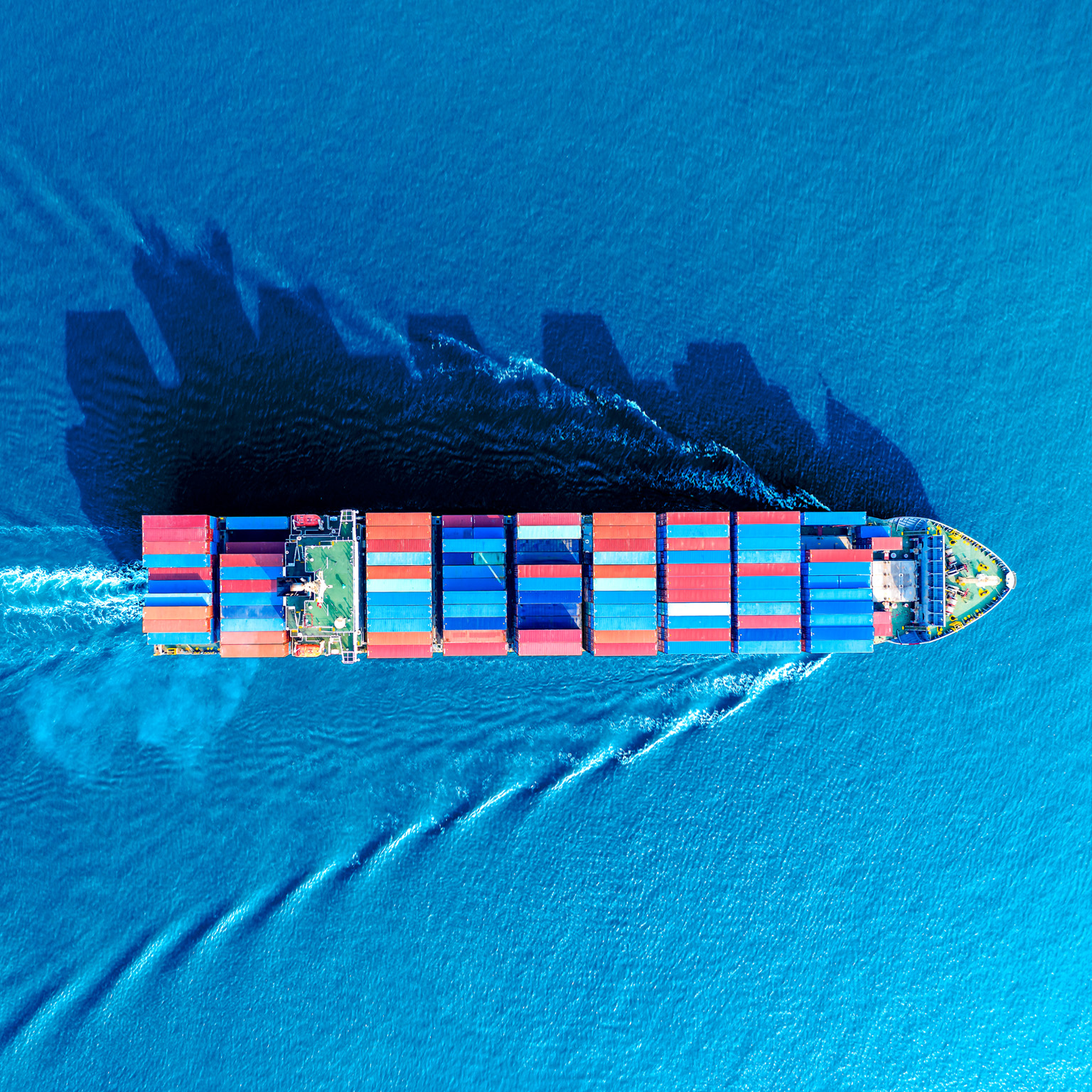 Aerial view of a container ship moving though the water