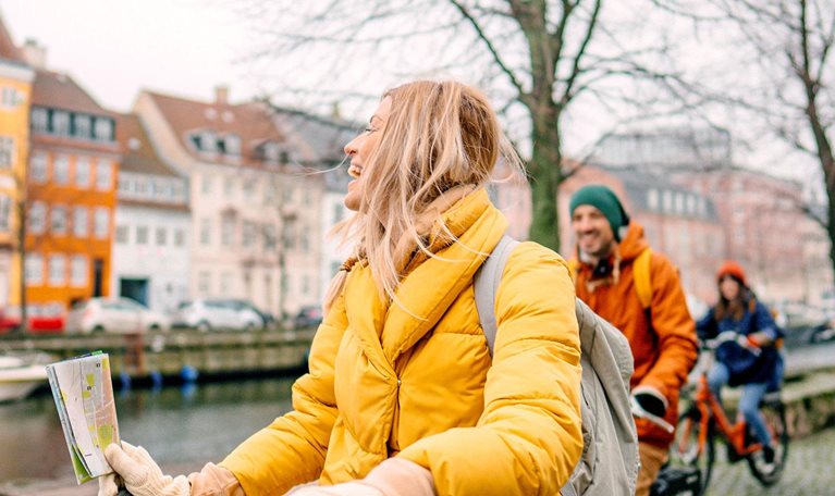 A female travel guide and her group bicycling through the town