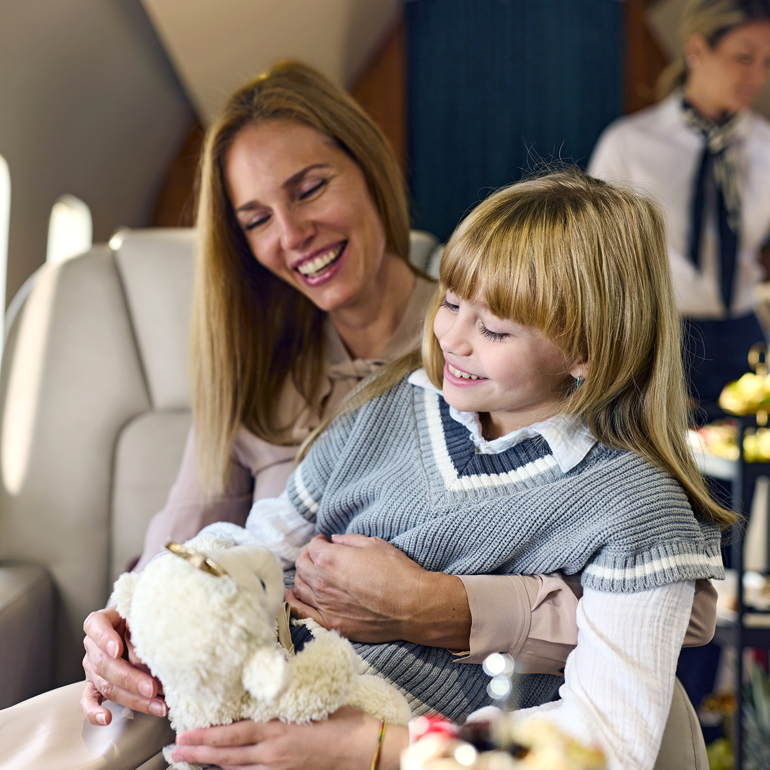 Happy mother and daughter traveling on a plane.