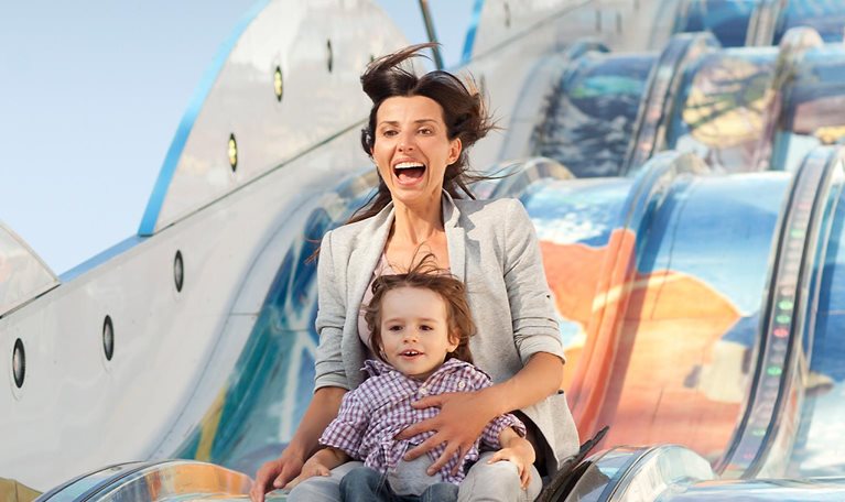Mother and her son on a slide at the carnival