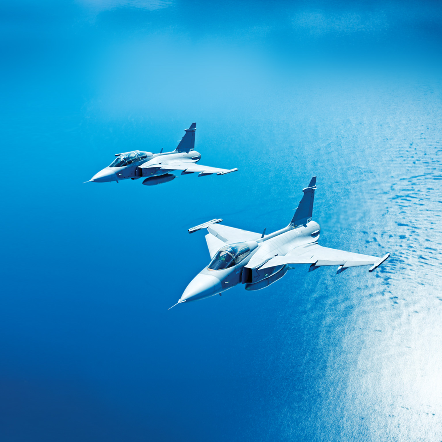 Military planes in flight over the ocean