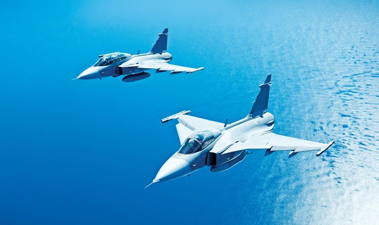 Military planes in flight over the ocean