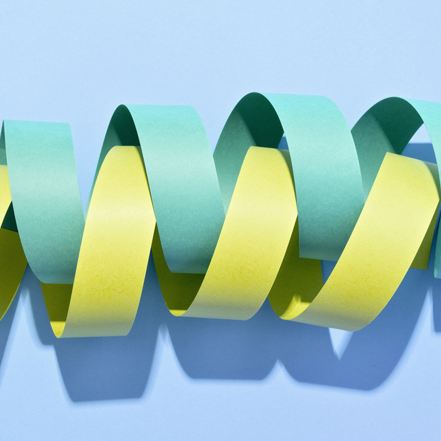 Two twisted paper stripe coils wrapped in helix shape. - stock photo