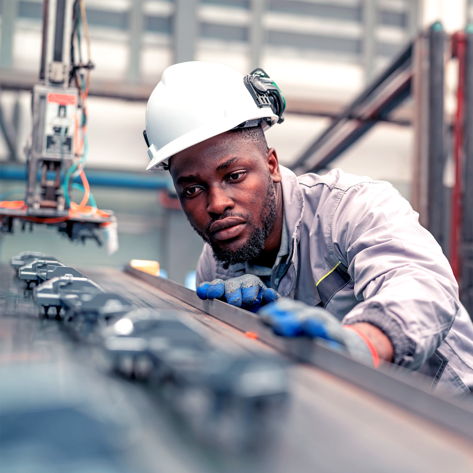 Quality engineer working in the automotive industry while checking the quality of components of automotive parts in the production line. 