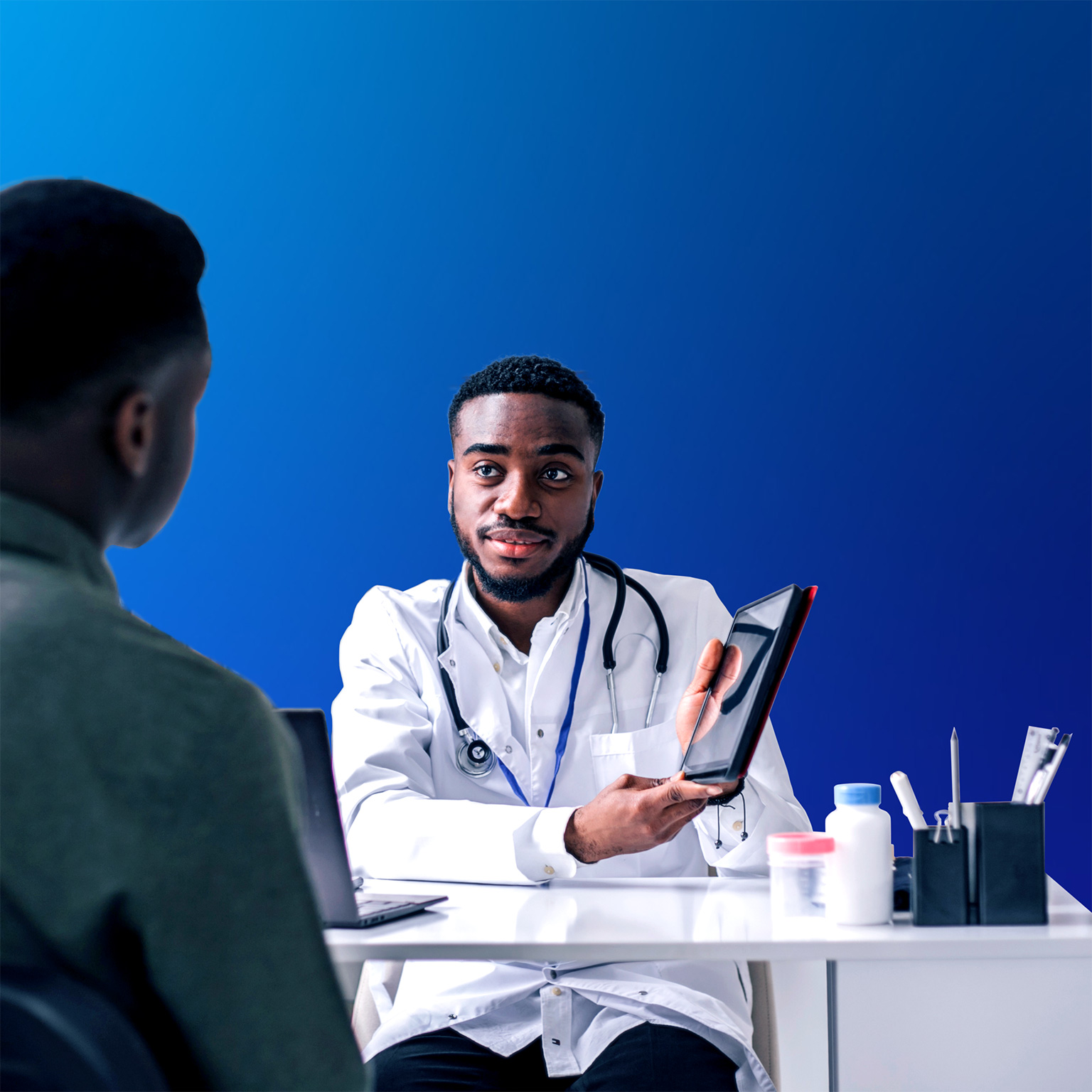 Young African man having an African-American man doctor's appointment at medical clinic.