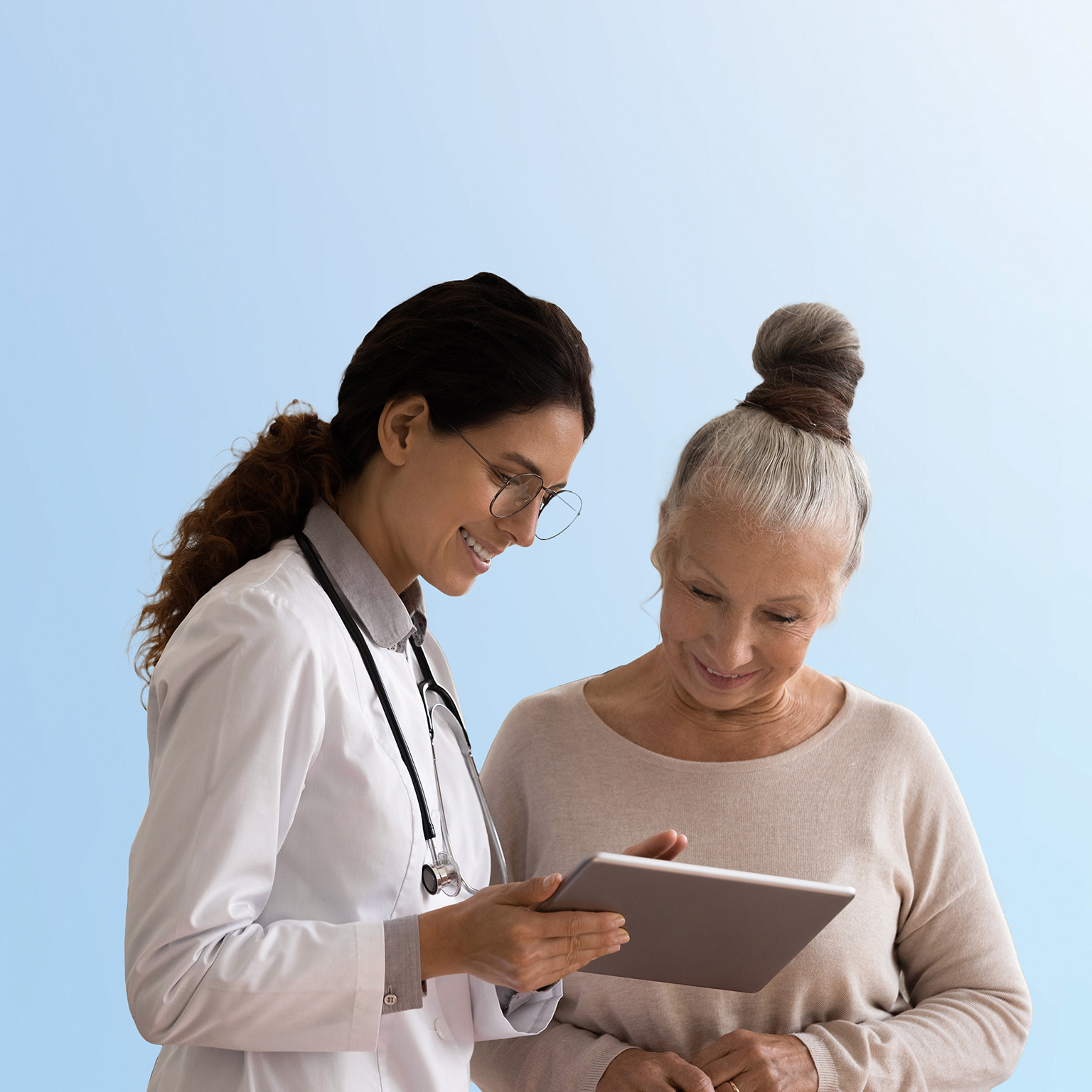 Happy doctor and senior patient use tablet at consultation