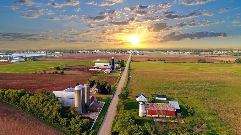 Idyllic rural agricultural landscape with dramatic sky at dawn