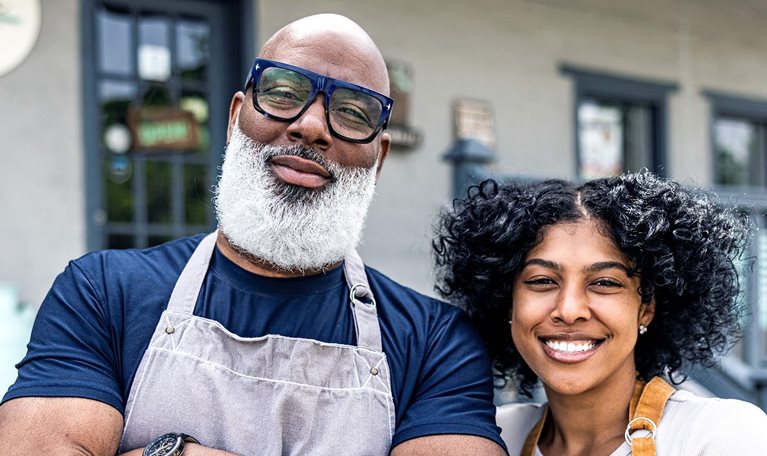 Portrait of father and daughter small business owners in front of family business